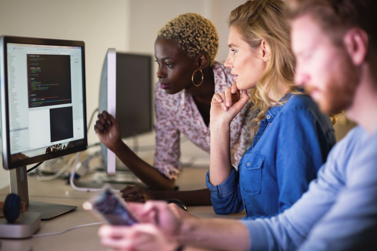 Une developpeuse web montre son travail à deux collaborateurs