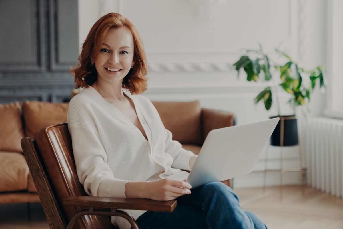 Une freelance souriante travaille dans son salon