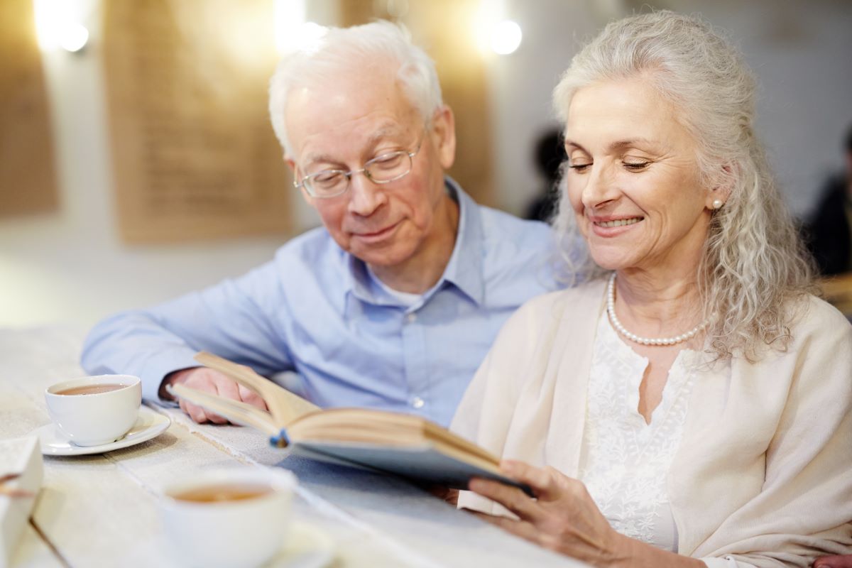 Un couple de retraité lit un livre