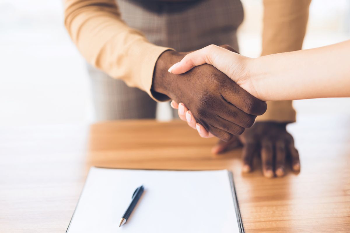 Deux personnes se serrent la main après avoir signé un contrat