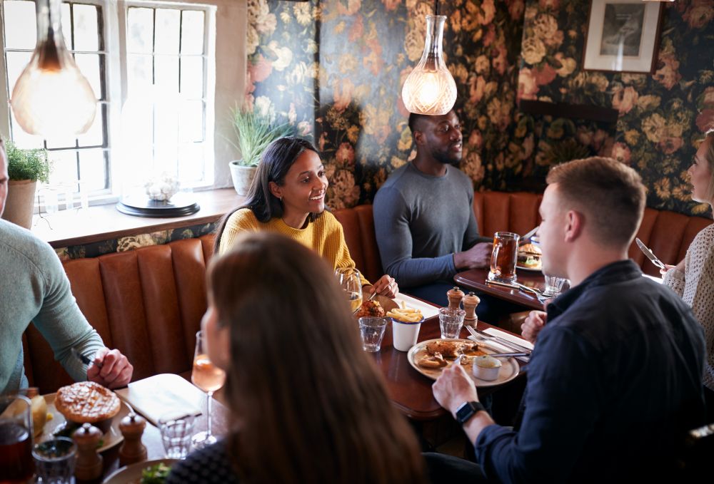 Groupe de personnes mangeant dans le restaurant d'un pub anglais traditionnel animé 