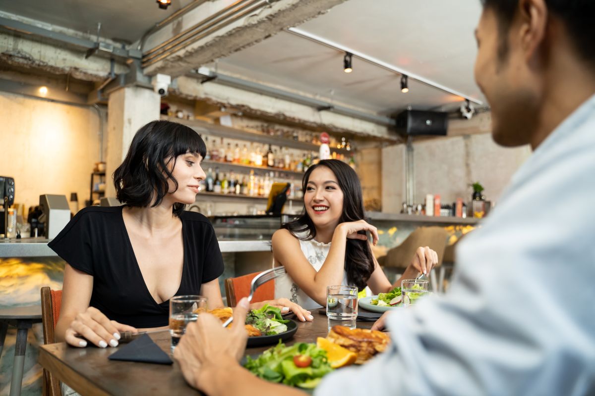 Groupe de jeunes amis assis au restaurant mangeant de la nourriture ensemble pour le déjeuner 