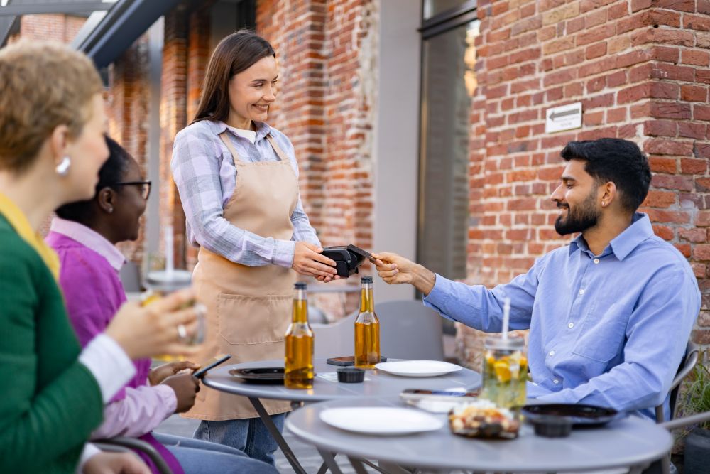 Le serveur accepte le paiement à la table du restaurant 