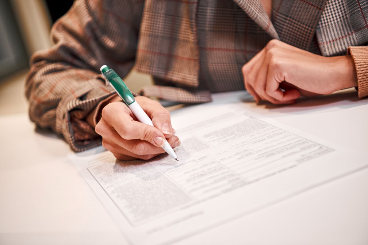 Une femme signe un contrat de travail