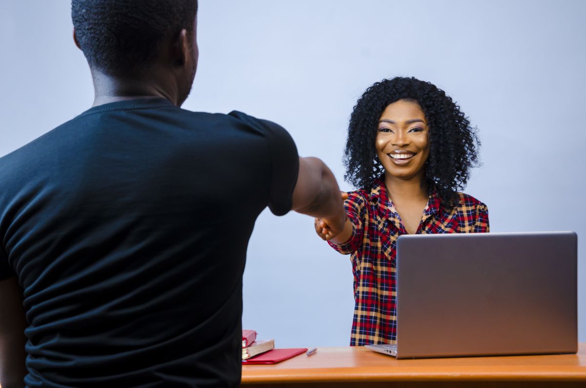 Jeune femme d'affaires souriante après avoir signé un contrat avec un partenaire commercial