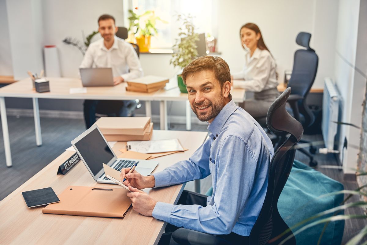 Un homme souriant tient un carnet sur le lieu de travail 