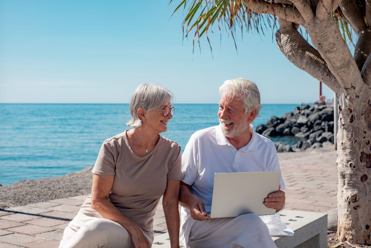Un couple de retraité rit ensemble à la plage