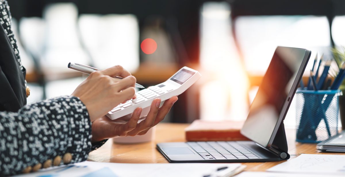 Un freelance calcule ses factures sur une calculatrice